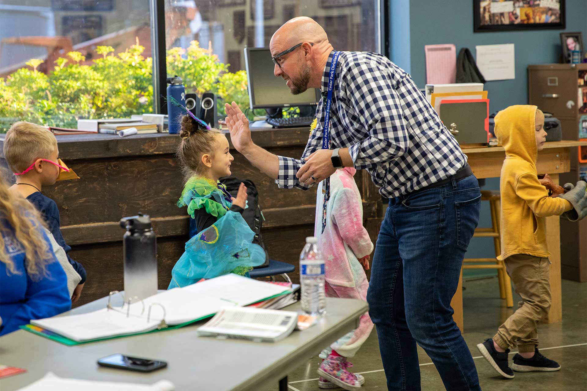 teacher giving toddler a high-five.