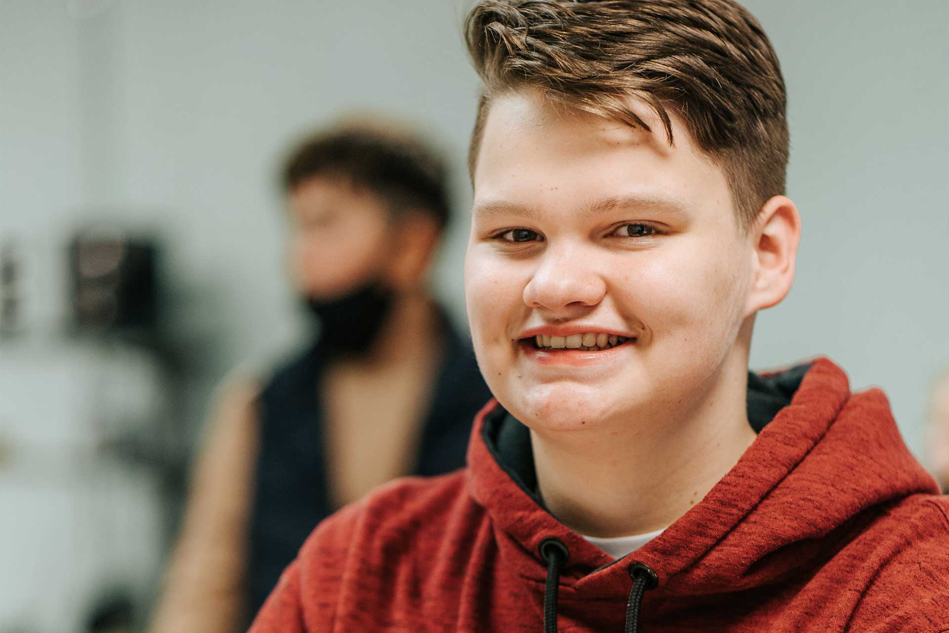 student wearing a red sweatshirt smiling