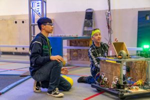 image of two students working on a robot project.