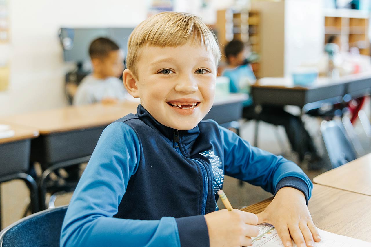 image of a young student smiling and writing