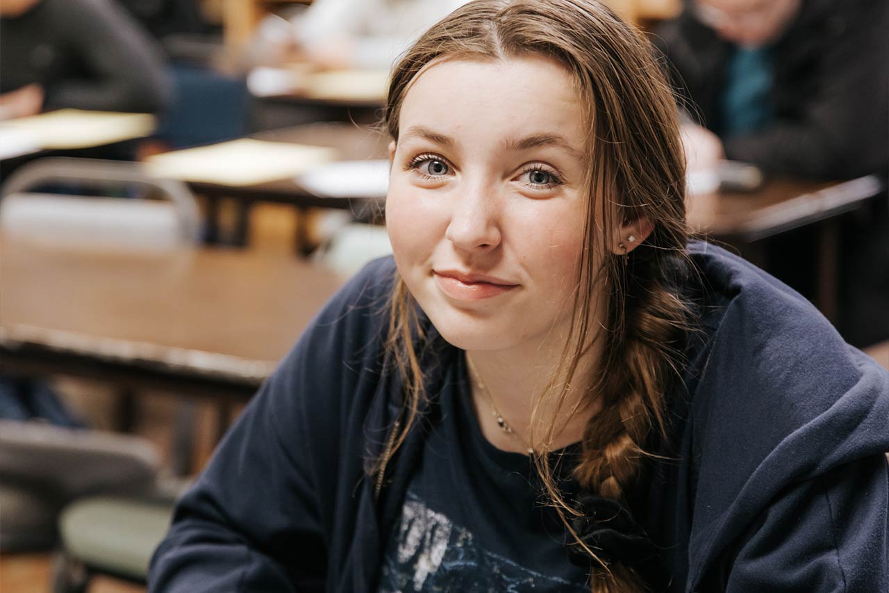 image of a young female high school student looking up at the cameral smiling